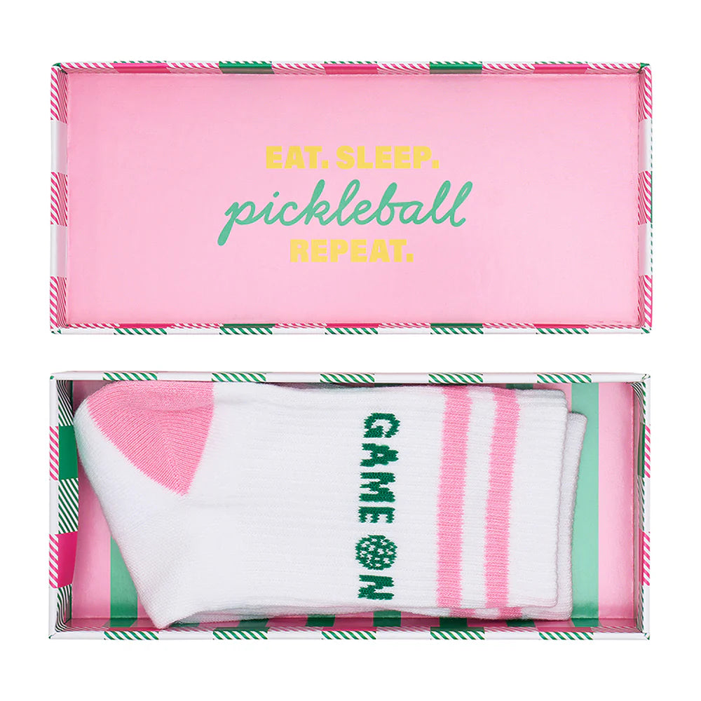 Pink and green pickleball-themed packaging with GAME ON socks inside