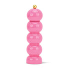 Stack of pink cylindrical objects with a gold top on a white background