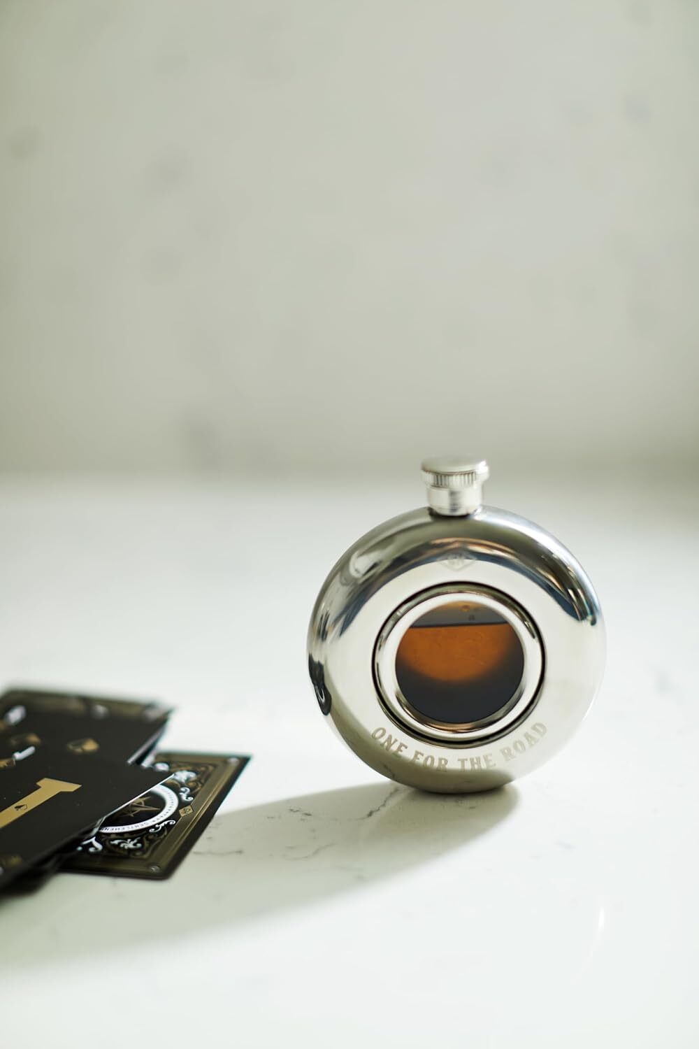 Silver Hip Flask with engraving saying one for the road with liquid inside showing it filled