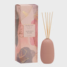 Pink diffuser bottle with wooden sticks and decorative box on a white background inspired by plums