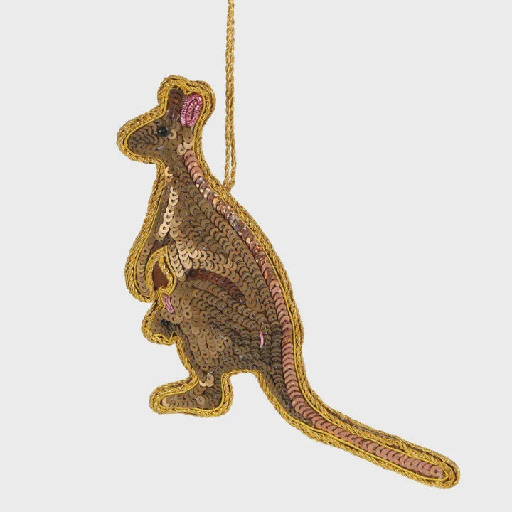A sequin decoration in the shape of a kangaroo with gold and pink sequins on a white background.